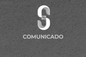 Sobre um fundo cinza escuro há um S estililizado da marca do SINJUS-MG, na cor branca, abaixo dele está escrito "Comunicado".