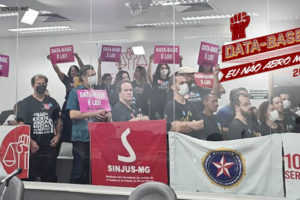 Foto de dirigentes do SINJUS e servidores ocupando a galeria do Plenarinho da ALMG com cartazes e faixas defendendo a aprovação da Data-Base 2022.