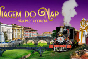A imagem apresenta um fundo em tons de roxo e rosa, com destaque para os dizeres: “Viagem do NAP – Não perca o trem...". A viagem, organizada pelo SINJUS-MG, acontecerá de 23 a 25 de maio. Há um aviso em letras destacadas dizendo que “as vagas estão acabando” e que há 5% de desconto para filiadas(os). Um botão azul convida: “Inscreva-se pelo formulário!”. Na parte inferior, aparece uma colagem vibrante da cidade de Tiradentes, com destaque para a famosa igreja de fachada branca e amarela e um trem turístico em movimento, reforçando o clima histórico e acolhedor do destino. O evento é promovido pelo NAP.