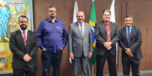Grupo de 5 homens brancos vestidos socialmente em reunião de dirigentes sindicais com o presidente do TJMG, o desembargador José Arthur Filho que está no centro da imagem.