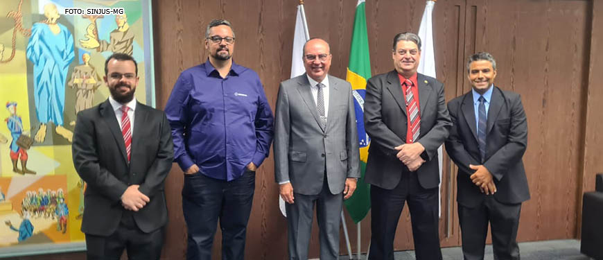 Grupo de 5 homens brancos vestidos socialmente em reunião de dirigentes sindicais com o presidente do TJMG, o desembargador José Arthur Filho que está no centro da imagem.