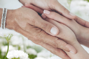 Imagem acessível: A imagem mostra mãos sobrepostas em um gesto de acolhimento e apoio, com flores brancas ao fundo. Em destaque, o texto “Você sabia que filiados ao SINJUS contam com Auxílio-Funeral?”, apresentando o benefício exclusivo aos filiados. Na base, a logomarca do SINJUS-MG.