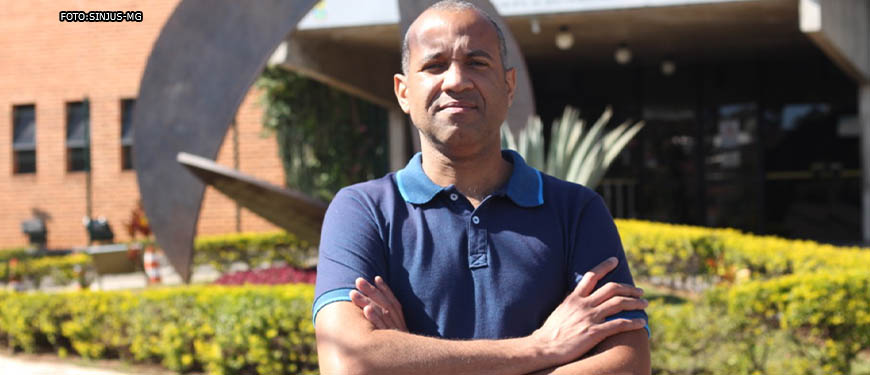 Ao fundo está a fachada da Câmara Municipal de Belo Horizonte, em frente está Wagner Ferreira, um homem negro, de cabelos curtos e grisalhos, ele veste uma camisa polo azul. Conteúdo textual: REPRESENTAVIDADE - Wagner do SINJUS vai assumir como vereador em Belo Horizonte.