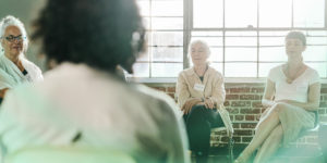 Imagem Acessível: A imagem mostra um grupo de pessoas sentadas em círculo, em ambiente acolhedor e iluminado, durante a prática voltada ao bem-estar. O texto em destaque convida à participação em mentoria promovida pelo SINJUS sobre neurociência respiratória e breathwork, associando a iniciativa ao cuidado com a saúde mental e ao desenvolvimento pessoal por meio de técnicas de respiração consciente.