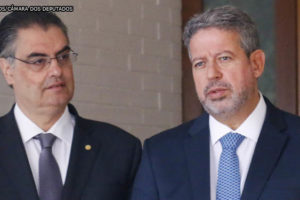 Registro de entrevista Coletiva de Imprensa com o Dep. Arthur Lira ao microfone (PP-AL) , ele é um homem branco de cabelos grisalhos e curtos e usa uma barba curta, ele está vestido socialmente. Ao lado de Arthur Lira estão os deputados Lafayette de Andrada (REPUBLICANOS - MG) e Danilo Forte (UNIÃO - CE), os dois são homens brancos, vestem trajes sociais e tê cabelos curtos e castanhos escuros. Conteúdo textual: Reforma Administrativa - Lira diz que pode retomar discussão sobre PEC 32 na próxima semana; se reeleito, Bolsonaro pode acelerar aprovação