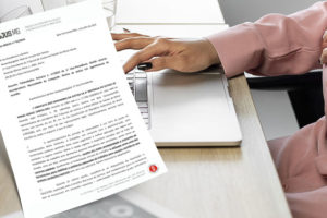 Montagem de uma mulher grávida sentada em frente a uma mesa com um notebook à sua frente. Ao lado dela, há uma representação de um ofício do SINJUS-MG e o texto: "SINJUS requer revogação da Portaria n. 17 e reunião com 1º vice-presidente do TJMG"