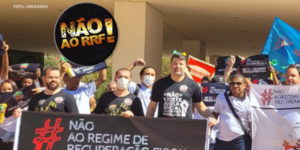 Grupo de manifestantes da 'Frente de Sindicatos do Funcionalismo contra o RRF' estão em frente à Cidade Administrativa, sede do Governo de MG. Eles estão com faixas de protesto contra o Regime de Recuperação Fiscal. Neste grupo estão dirigentes sindicais do SINJUS- MG, Alexandre Pires (coordenador-geral) e Felipe Rodrigues (diretor de finanças).