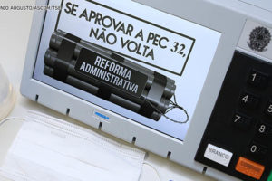 Urna eletrônica com a aplicação digital da seguinte frase na tela do equipamento: Se aprovar a PEC 32, não volta.
