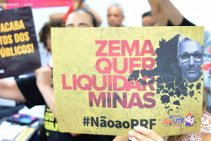 Fotografia com público no Plenarinho IV, na foto se vê pessoas protestando contra a RRF, utilizando cartazes variados.