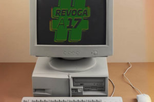 Computador antigo exibe tela preta com a mensagem #REVOGAA17 em verde.