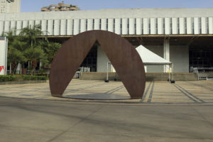 Fachada da Assembleia Legislativa de Minas Gerais com escultura em ferro em destaque.