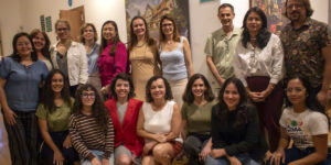 Imagem Acessível: Registro de dois momentos do evento Cinefem, do Núcleo das Mulheres do SINJUS-MG. Na parte superior, um músico toca piano, e abaixo aparece um grupo de participantes reunidos, sorrindo para a foto. Entre as filiadas e debatedores estão as diretoras Adriana Teodoro e Janaína Torres, que estão à frente da iniciativa. Conteúdo textual: SETEMBRO AMARELO - Cinefem discute as pressões que adoecem as mulheres a partir de Cisne Negro.