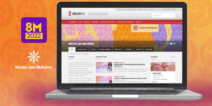 Fundo em tons laranja e roxo, com um notebook aberto e na tela a nova página do Núcleo das Mulheres no site do SINJUS-MG. Ao lado no notebook há um selo do 8M 2022 (em referência a 8 de Março, Dia Internacional das Mulheres) e a logo do Núcleo das Mulheres.