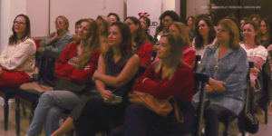 Foto de um grupo de mulheres, sentadas e atentas, participando do evento Papo Aberto do Núcleo das Mulheres do SINJUS.