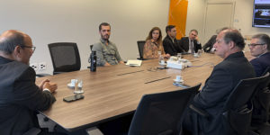 Imagem acessível: A imagem mostra uma reunião do Comitê Gestor de Atenção Integral à Saúde de Magistrados e Servidores do TJMG, com representantes reunidos em torno de uma mesa. No centro da arte, o título “Comitê debate ações de saúde e SINJUS cobra melhorias nas condições de trabalho do TJMG”. Na base da imagem, aparece o logo do SINJUS-MG.