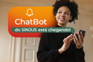 A imagem anuncia a chegada do ChatBot do SINJUS. Em destaque, aparece uma mulher sorridente segurando um celular, simbolizando praticidade e acesso digital. O texto tem o aviso: “O ChatBot do SINJUS está chegando!”, destacando a novidade como um recurso de atendimento contínuo aos filiados.