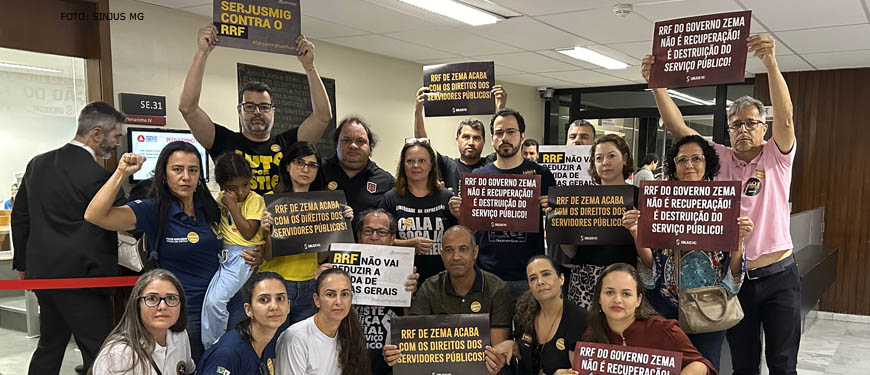 A imagem mostra um grupo de pessoas reunidas, segurando cartazes e protestando