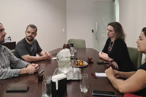 Na foto estão o coodenador-geral do SINJUS-MG, Alexandre Pires e o diretor de Assuntos Jurídicos do Sindicato, Felipe Rodrigues. Os dois dirigentes estão em uma mesa de reunião com as representantes do Sindalemg, a coordenadora-geral do Sindalemg, Gisele Paola Antonioli, e a coordenadora administrativa, Daniela Johannes Rad Fonseca. Conteúdo textual: Atuação conjunta SINJUS e Sindalemg unem forças em favor de Datas-Bases e Auxílios e contra o RRF.