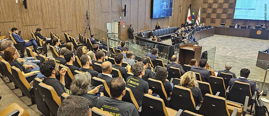 A foto mostra o auditório do Órgão Especial do TJMG ocupado por servidoras e servidores que atenderam à convocação do SINJUS-MG para acompanhar a sessão de 9 de setembro. Parte dos participantes veste camisas pretas com a frase “Só a Luta Te Garante”.