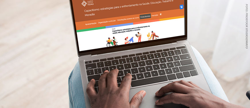 Imagem Acessível: A imagem mostra um notebook aberto na página do Campus Virtual Fiocruz, com o curso “Capacitismo: estratégias para o enfrentamento na saúde, educação, trabalho e moradia”. Conteúdo textual: #NPDIndica - Fiocruz abre inscrições para curso gratuito sobre enfrentamento ao capacitismo.