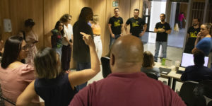A imagem mostra os servidores em roda em um corredor da unidade Afonso Pena 1.500 do TJMG, enquanto os dirigentes sindicais Alexandre Pires, Janaína Torres, Felipe Tomanini, Felipe Rodrigues e Alexandre Gomes ouvem um relado de uma servidora que gesticula.