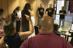 A imagem mostra os servidores em roda em um corredor da unidade Afonso Pena 1.500 do TJMG, enquanto os dirigentes sindicais Alexandre Pires, Janaína Torres, Felipe Tomanini, Felipe Rodrigues e Alexandre Gomes ouvem um relado de uma servidora que gesticula.