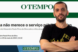 Montagem digital com fundo de uma tela com um artigo na página do veículo "O Tempo", na frente está o coordenador-geral do SINJUS-MG, Alexandre Pires, um homem branco de cabelos e barba castanhos bem curtos, ele veste uma camisa preta de luta do sindicato e está com os braços cruzados.