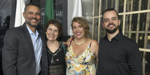 Alex Aguiar, homem de barba grisalha e cabelo curto, Sandra Freitas, mulher de cabelos castanhos curtos, Lina Rocha, mulher loira de cabelos na altura dos ombros, e Felipe Rodrigues, homem de barba e cabelos curtos, posam sorridentes lado a lado durante um evento.