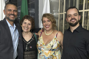 Alex Aguiar, homem de barba grisalha e cabelo curto, Sandra Freitas, mulher de cabelos castanhos curtos, Lina Rocha, mulher loira de cabelos na altura dos ombros, e Felipe Rodrigues, homem de barba e cabelos curtos, posam sorridentes lado a lado durante um evento.