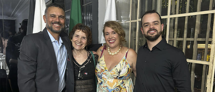Alex Aguiar, homem de barba grisalha e cabelo curto, Sandra Freitas, mulher de cabelos castanhos curtos, Lina Rocha, mulher loira de cabelos na altura dos ombros, e Felipe Rodrigues, homem de barba e cabelos curtos, posam sorridentes lado a lado durante um evento.