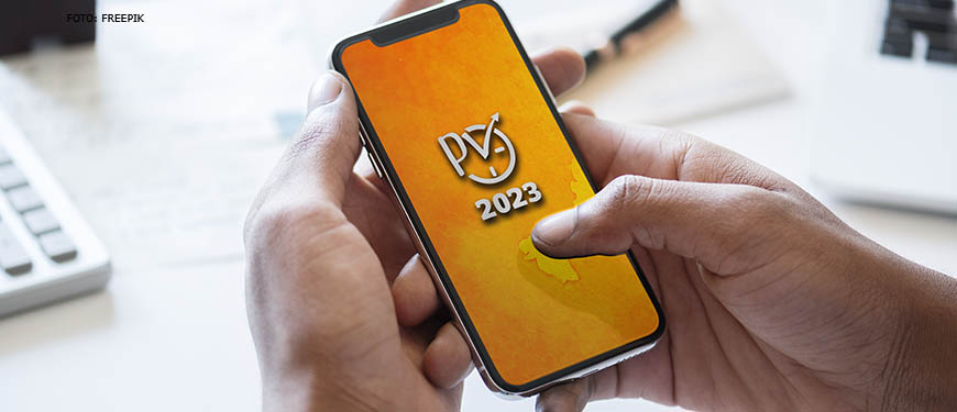 Se vê a imagem de uma pessoa segurando um celular, onde o fundo de tela do mesmo está escrito "PV 2023" na cor cinza com o fundo amarelo.