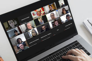 Montagem digital de um computador, na tela está uma reunião virtual da Fenajud, da qual participam representantes dos sindicatos da Justiça de todo o Brasil.