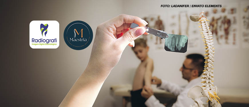 A imagem mostra um consultório médico onde um profissional da saúde em quiropraxia , que aparentemente é médico ou fisioterapeuta, está examinando um menino sem camisa. Em primeiro plano, há um modelo anatômico de uma coluna vertebral em cima de uma mesa ao lado se vê uma montagem digital de um braço segurando um raio x por prendedor metálico. Ao fundo, pode-se ver cartazes com ilustrações do corpo humano na parede. O profissional está de óculos e parece estar focado na avaliação do paciente.