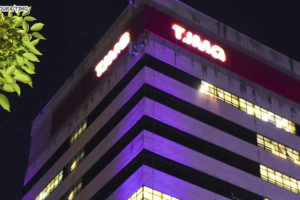 Vista noturna da fachada da sede do TJMG iluminada com luzes rosadas. Conteúdo textual: TJMG divulga intimação de candidatos à PV 2021 com documentos incorretos.