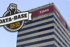 Logotipo da campanha Data-Base 2024-2025 com punho cerrado acima de faixa estilizada, sobreposto à fachada do edifício-sede do Tribunal de Justiça de Minas Gerais (TJMG), em Belo Horizonte, com céu azul ao fundo. Foto: SINJUS-MG.