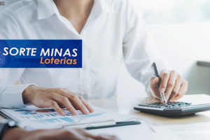 homem analisando documentos e utilizando uma calculadora. Em destaque logo da Sorte Minas Loterias.