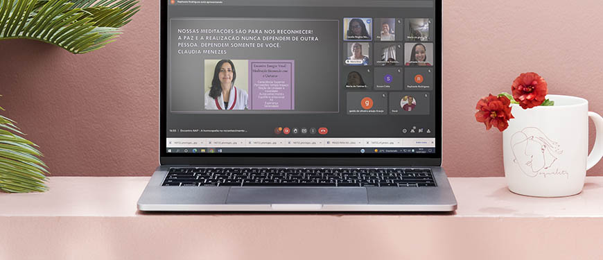 Uma reunião virtual é exibida numa tela de um laptop, que está sobre um fundo em tom salmão. Na tela há uma apresentação em slide e um mosaico com diversas pessoas que participam remotamente deste encontro. Conteúdo textual: APOSENTADOS E PENSIONISTAS - Benefícios da homeopatia e do equilíbrio energético são explicados no NAP