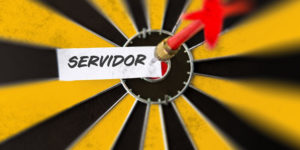 Imagem de um alvo amarelo e preto com um dardo vermelho cravado no centro. No ponto atingido há um papel com a palavra “Servidor” escrita em letras maiúsculas.