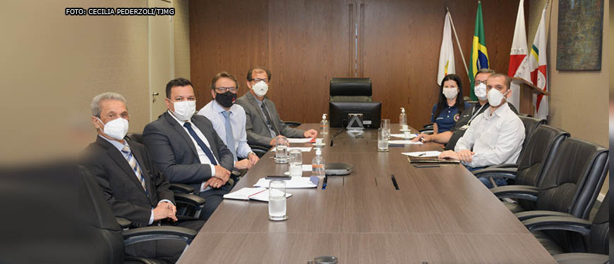 ampla mesa de reuniões sentados em ambos os lados estão os representantes dos servidores Eduardo Rocha Mendonça de Freitas, Diretor-Geral do SINDOJUS/MG, Elaine Mancilha Santos da FESOJUS-BR, o presidente do SERJUSMIG, Rui Viana, e o coordenador-geral do SINJUS-MG, Alexandre Pires. A direção do TJMG foi representada pelo juiz auxiliar da Presidência, Cássio Azevedo Fontenelle, e o secretário de Governança e Gestão Estratégica, Guilherme do Valle.