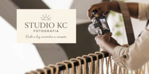 A imagem mostra uma mulher negra segurando uma câmera fotográfica e ajustando o foco em um ambiente iluminado. Sobre a imagem, o texto diz: “Eternize seus melhores momentos com o novo convênio de fotografia do SINJUS”. Abaixo, o logotipo do Studio KC Fotografia, acompanhado do slogan “Onde a luz encontra a emoção”. No canto superior esquerdo, está o título “Serviço”, e na base da imagem, o logotipo do SINJUS-MG.