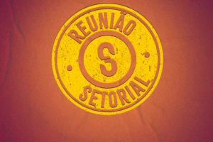 sobre uma textura de cartaz colado na parede, há um selo redondo, ao redor dele está escrito "Reunião Setorial" e no centro há o "S" do logo do SINJUS.