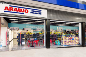 Imagem da fachada de uma das unidades da rede Araujo, com as portas abertas e muitas prateleiras com produtos expostos..
