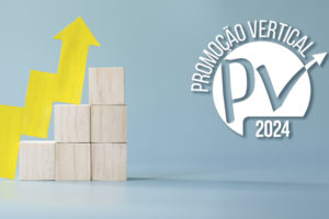 : A imagem mostra em um fundo azul-claro, blocos de madeira organizados em formato de escada, simbolizando crescimento na carreira. Ao lado, uma seta amarela em formato ascendente reforça a ideia de progressão profissional.