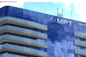 Imagem acessível: Fachada do prédio do MPT mostrando um prédio de arquitetura moderna, com vidros em tons de azul com a sigla e logotipo do MPT em um letreiro no topo.