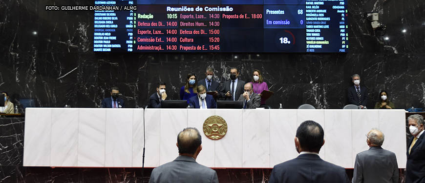 Deputados em votação no Plenário da ALMG, em destaque está a mesa diretiva da sessão com o painel luminoso ao fundo.