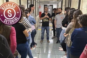 Servidores do TJMG reunidos em corredor de um setor na Unidade Goiás. Eles estão ouvindo o coordenador-geral do SINJUS-MG, Alexandre Pires que está acompanhado de dois dirigentes do Sindicato, Felipe Rodrigues (diretor de Assuntos Jurídicos) e Jonas Araújo (diretor de Assuntos Sociais, Culturais e de Saúde).