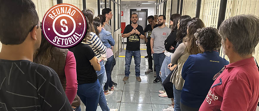 Servidores do TJMG reunidos em corredor de um setor na Unidade Goiás. Eles estão ouvindo o coordenador-geral do SINJUS-MG, Alexandre Pires que está acompanhado de dois dirigentes do Sindicato, Felipe Rodrigues (diretor de Assuntos Jurídicos) e Jonas Araújo (diretor de Assuntos Sociais, Culturais e de Saúde).