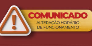 A imagem é um comunicado do SINJUS-MG sobre a alteração no horário de funcionamento. O fundo é vermelho, com um quadro amarelo central e um ícone de alerta no topo. Em destaque, aparece: “COMUNICADO — Alteração horário de funcionamento”.