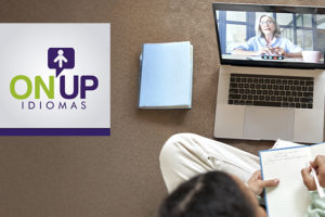 Imagem Acessível: A imagem mostra uma pessoa estudando em casa, com caderno, fones de ouvido e notebook onde aparece uma professora em chamada de vídeo. O texto diz: “Aprenda um novo idioma com condições especiais”. No canto direito, aparece o logo da ON UP Idiomas.