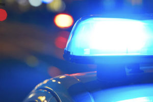 Imagem acessível: Foto noturna de uma viatura policial com foco no giroflex azul.